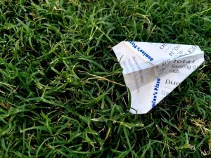 receipt not handled efficiently, folded into a plane lying on the grass